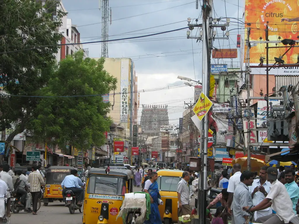 Busy Chennai road lined with shops and auto-rickshaws